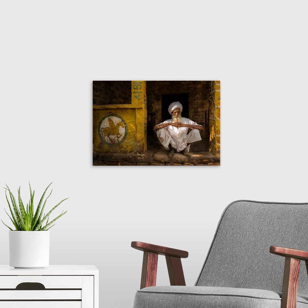 A modern room featuring A portrait of a man sitting in a yellow doorway with a painting of a pegasus painted on the wall ...