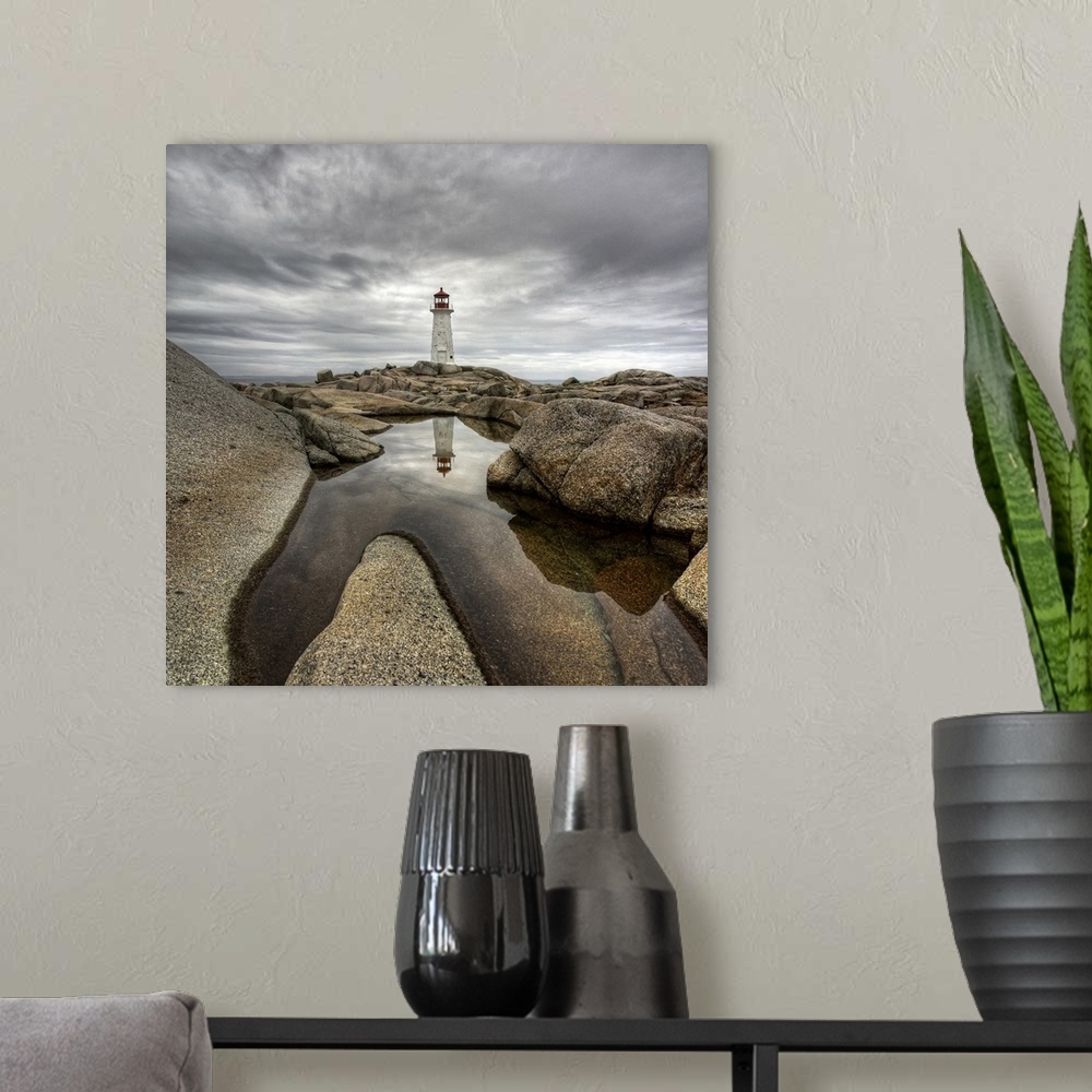 A modern room featuring A distant Canadian lighthouse casting its reflection in a rocky tidal pool in the foreground.