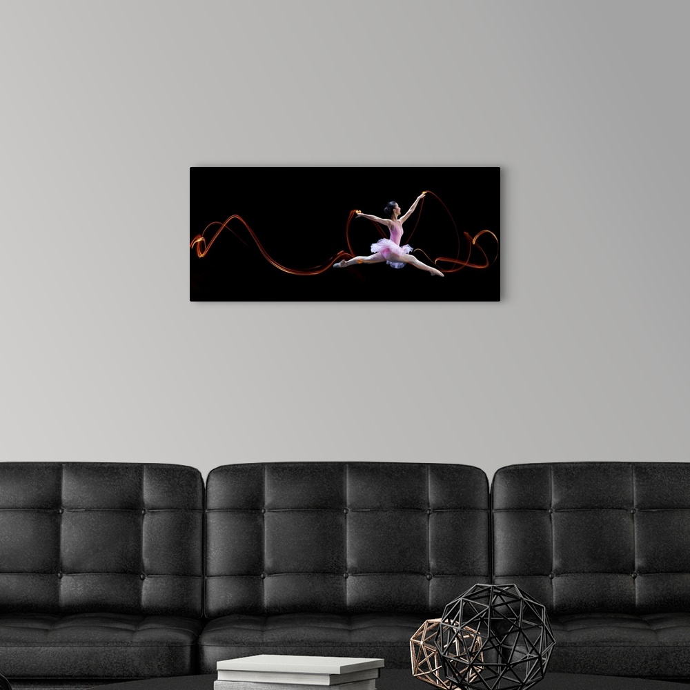 A modern room featuring A ballerina leaping, with light trails left in the air from her movements.