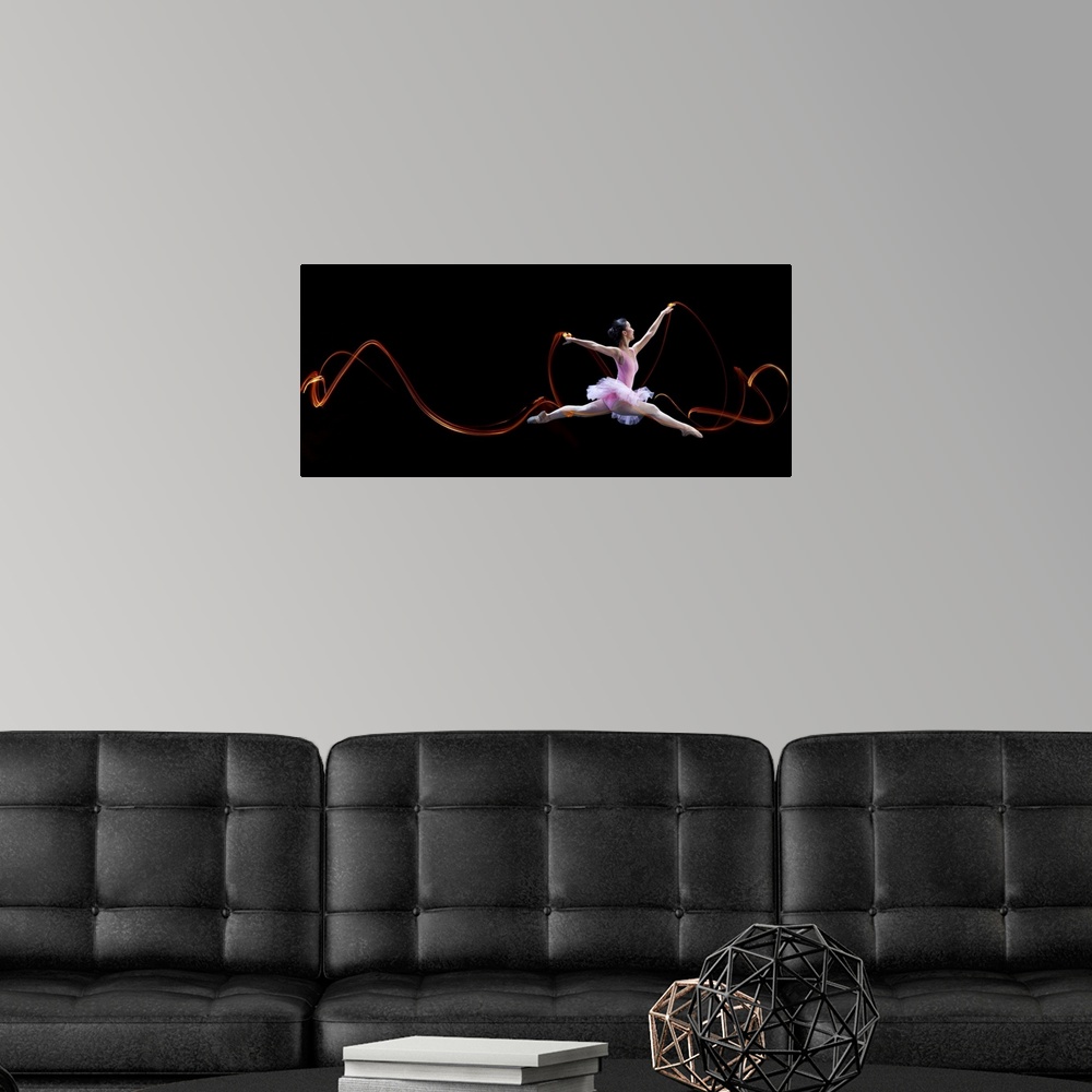 A modern room featuring A ballerina leaping, with light trails left in the air from her movements.
