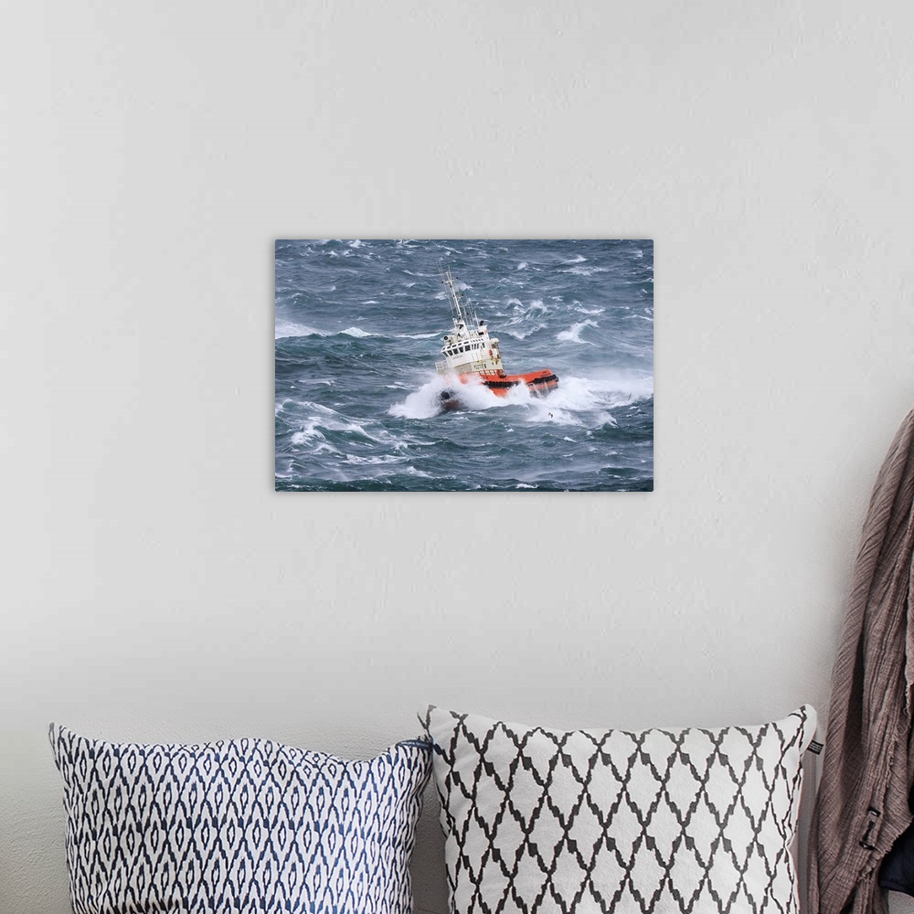 A bohemian room featuring A tugboat navigates the rough ocean waves off the Icelandic coast.