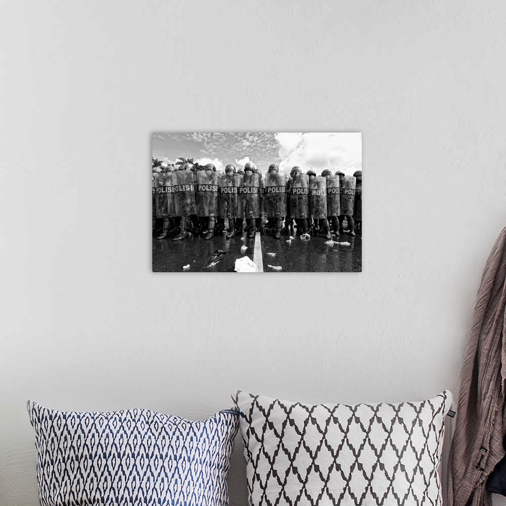 A bohemian room featuring A black and white photograph of a police barricade.