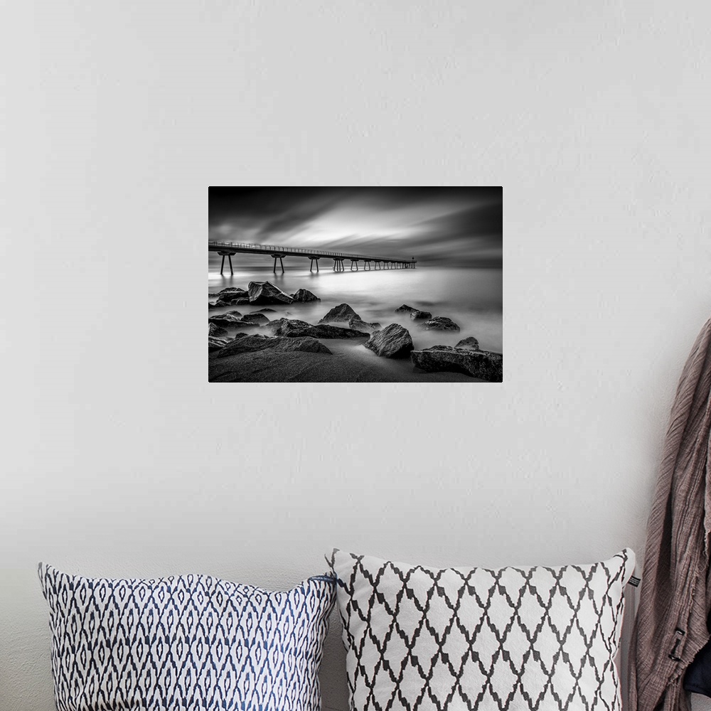 A bohemian room featuring Long exposure black and white photograph of a seascape in Pint Del Petroli, Spain.