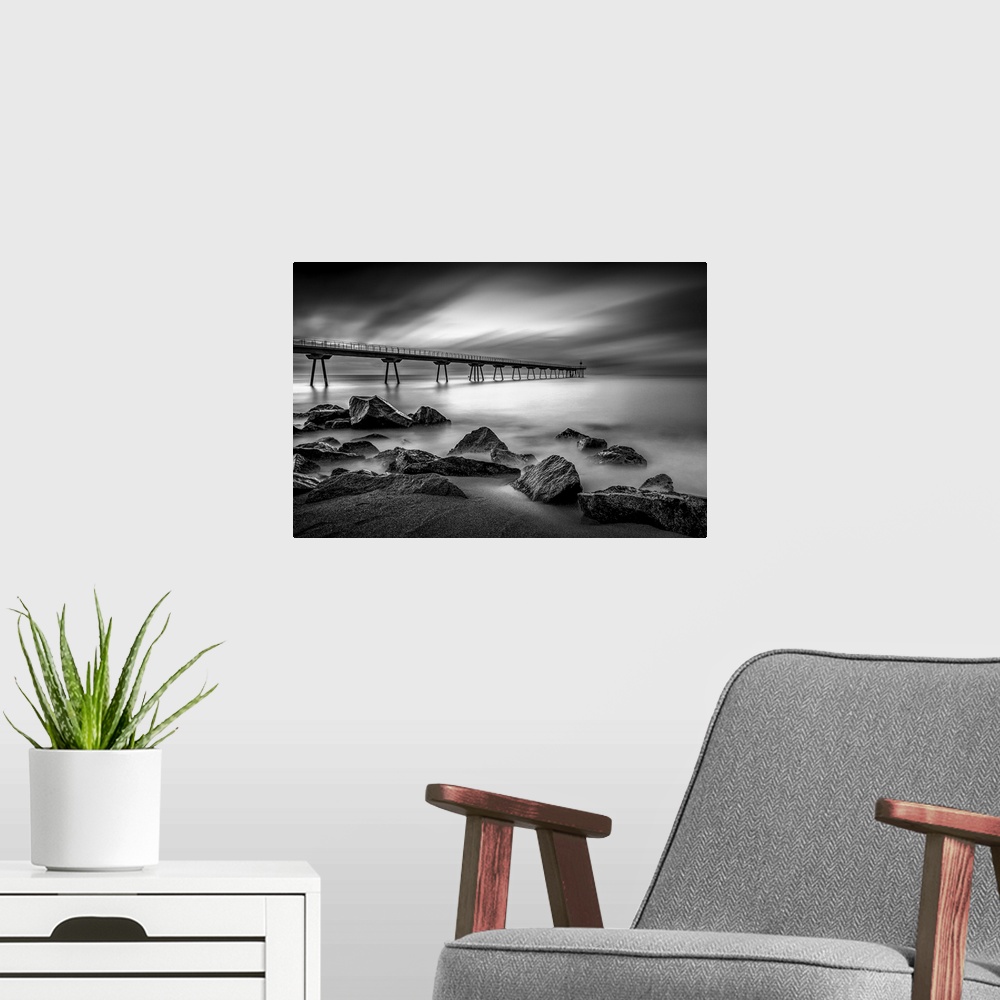 A modern room featuring Long exposure black and white photograph of a seascape in Pint Del Petroli, Spain.