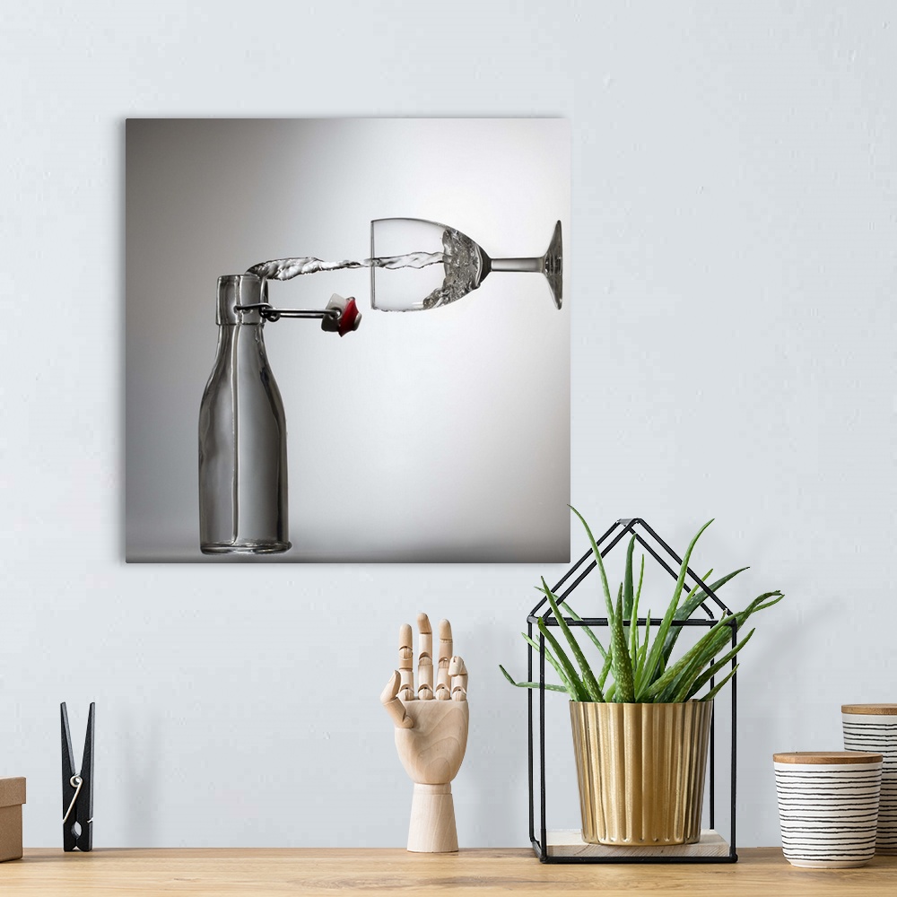 A bohemian room featuring Conceptual image of water being poured from a bottle into a glass, appearing sideways.