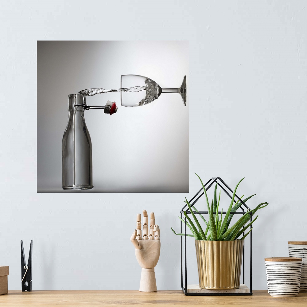 A bohemian room featuring Conceptual image of water being poured from a bottle into a glass, appearing sideways.