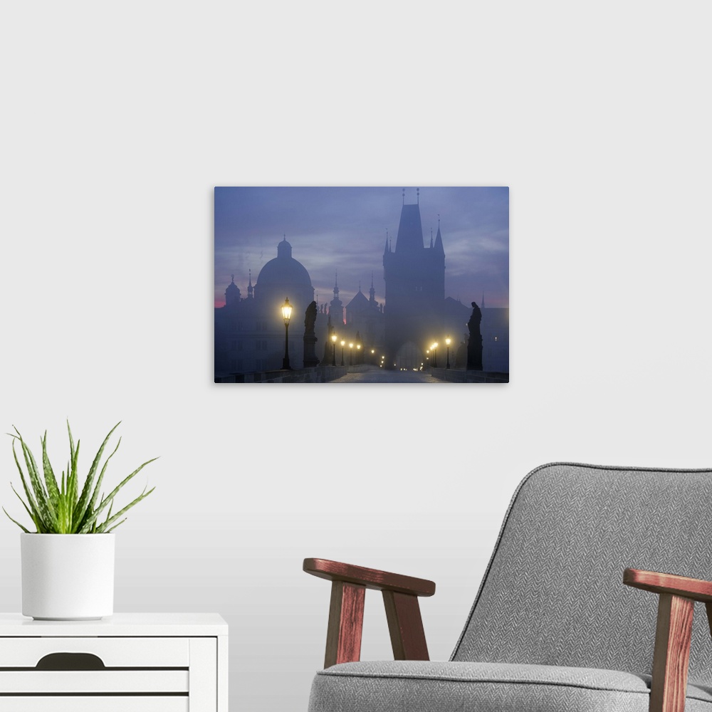 A modern room featuring Charles Bridge in Prague in the early morning mist.