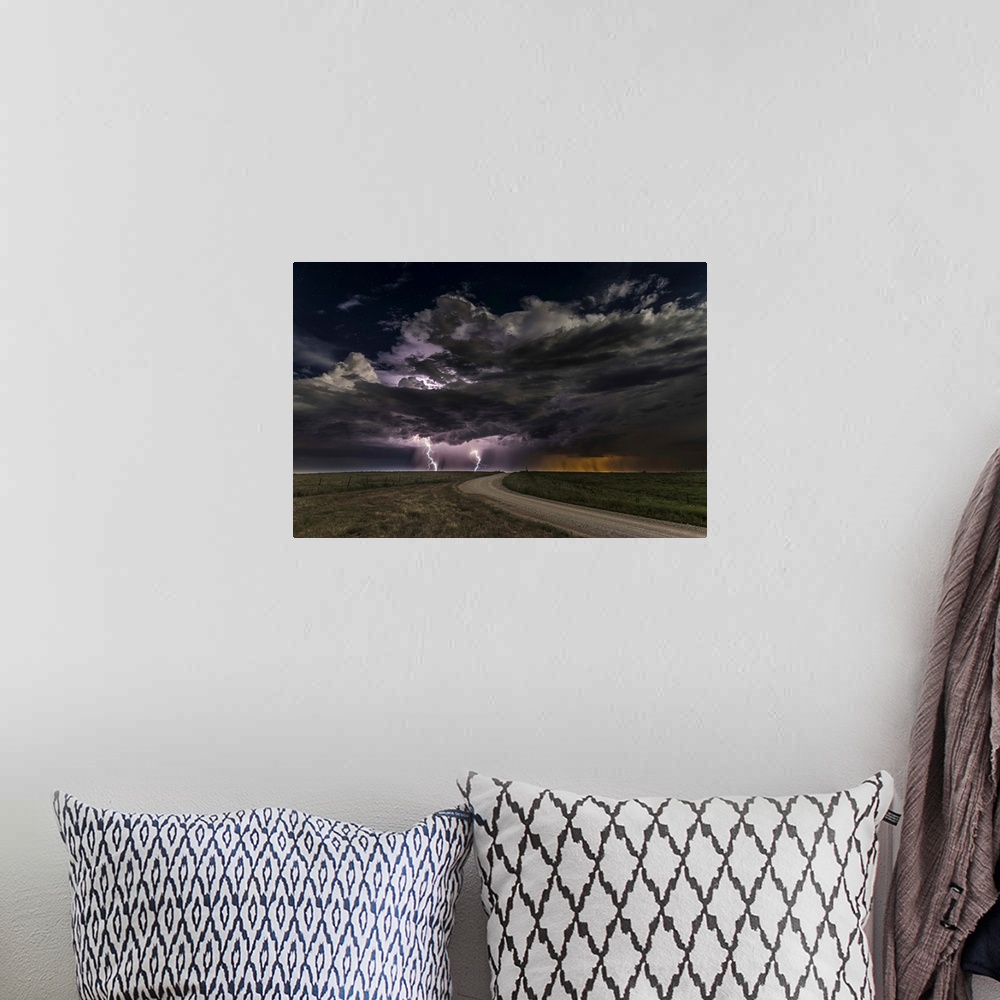 A bohemian room featuring Dramatic clouds throw down bright purple bolts of lightning on a prairie landscape.