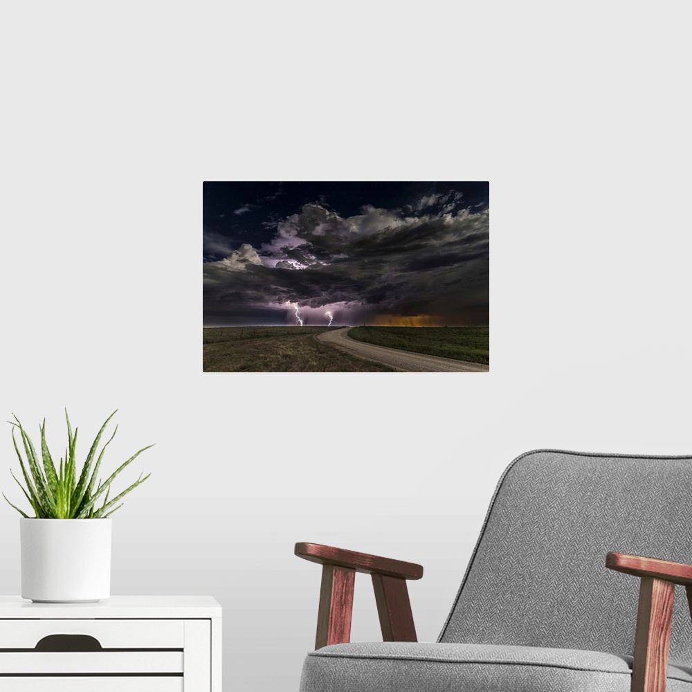 A modern room featuring Dramatic clouds throw down bright purple bolts of lightning on a prairie landscape.