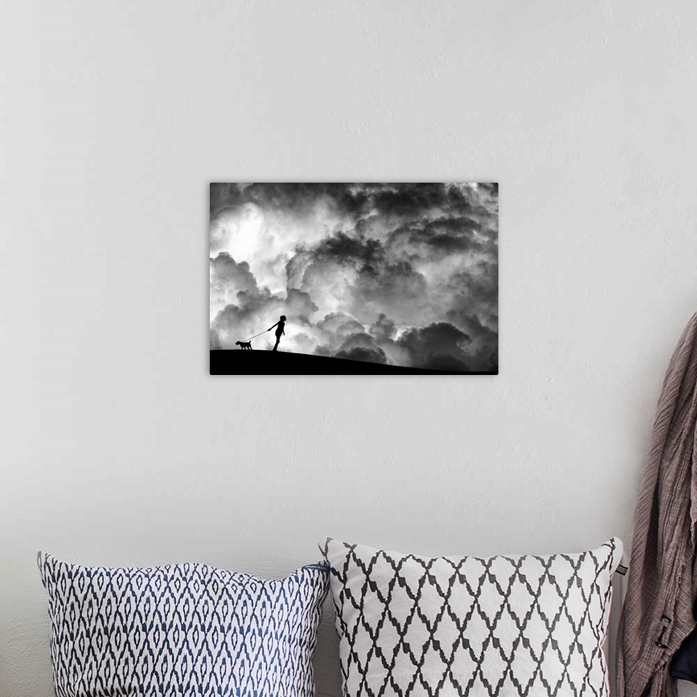 A bohemian room featuring A girl holding a dog on a leash in silhouette against a background of dramatic clouds.