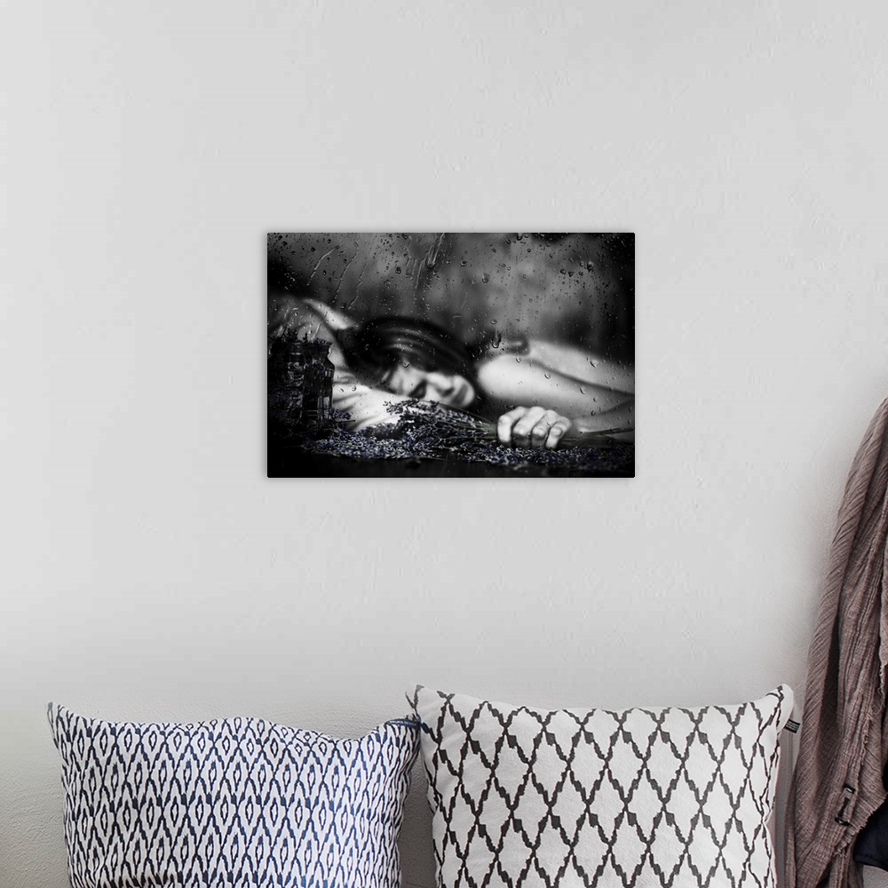 A bohemian room featuring Black and white image of a woman laying down with falling raindrops.