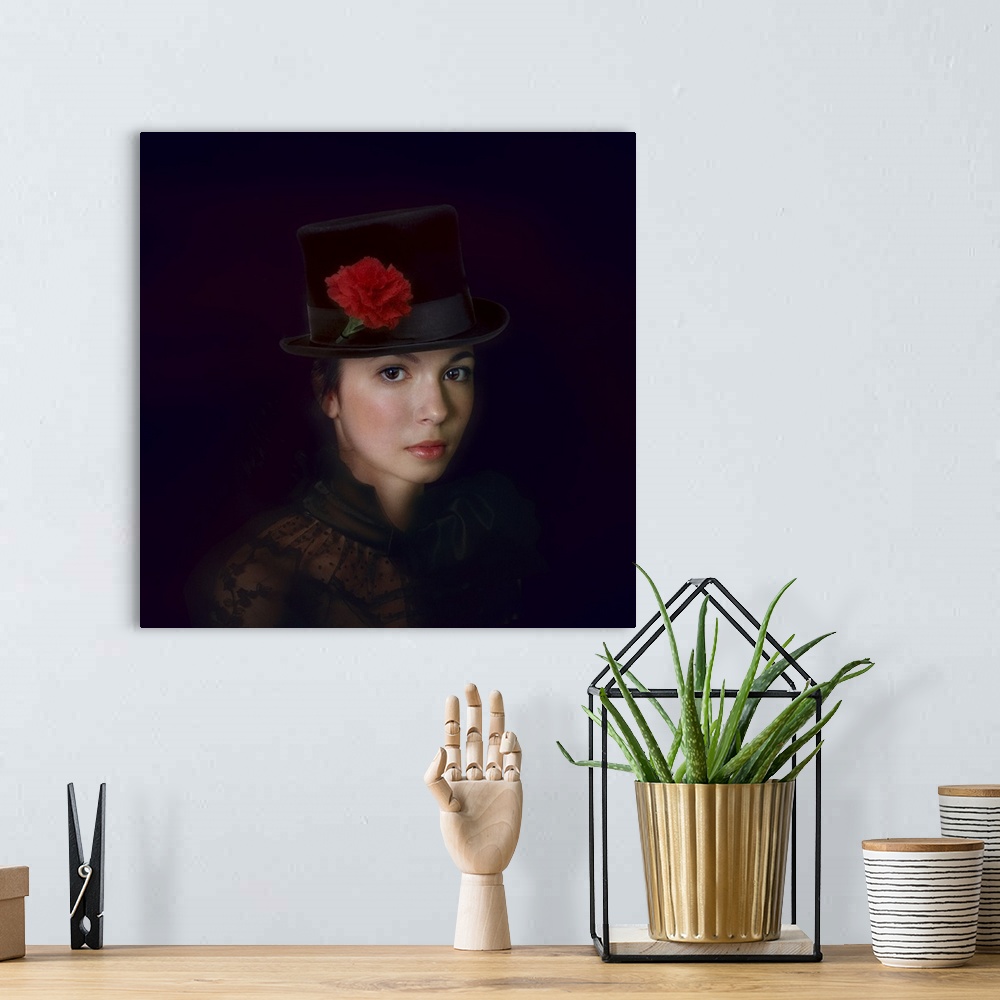 A bohemian room featuring Portrait of a lovely young woman wearing a top hat decorated with a red carnation.