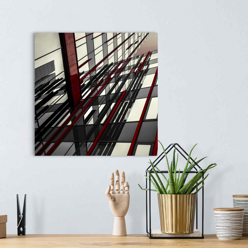 A bohemian room featuring Abstract photograph of intersecting red and black panels and windows in a building.