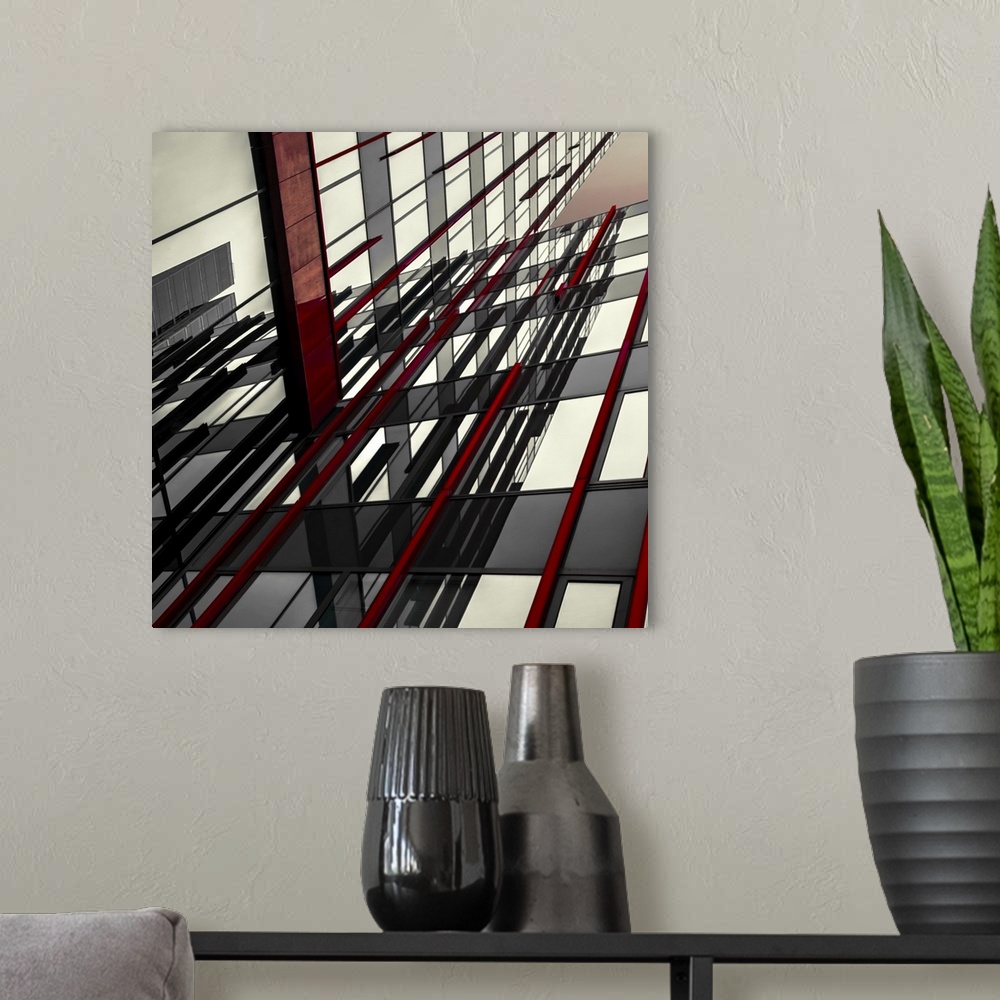 A modern room featuring Abstract photograph of intersecting red and black panels and windows in a building.