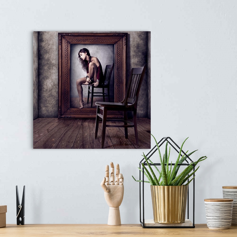 A bohemian room featuring Conceptual image of a woman sitting on a chair in a large picture frame, with an empty chair in t...