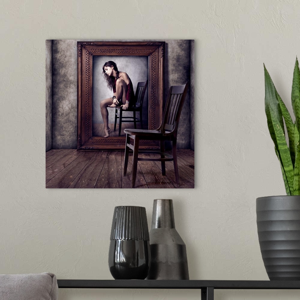 A modern room featuring Conceptual image of a woman sitting on a chair in a large picture frame, with an empty chair in t...