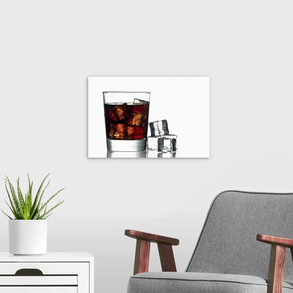 A modern room featuring A photo of a glass of fresh icy cold cola with ice cubes next to.