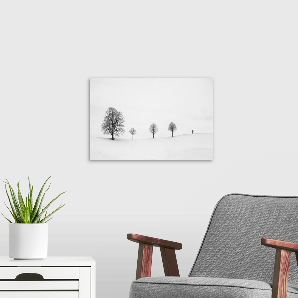 A modern room featuring Minimalist image of a row of three small trees with one larger tree and a skier.