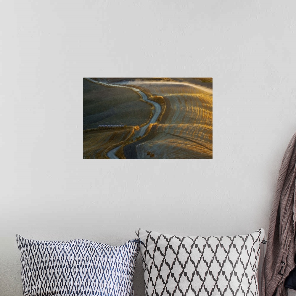 A bohemian room featuring Aerial view of a road winding through a rural landscape in the early morning.