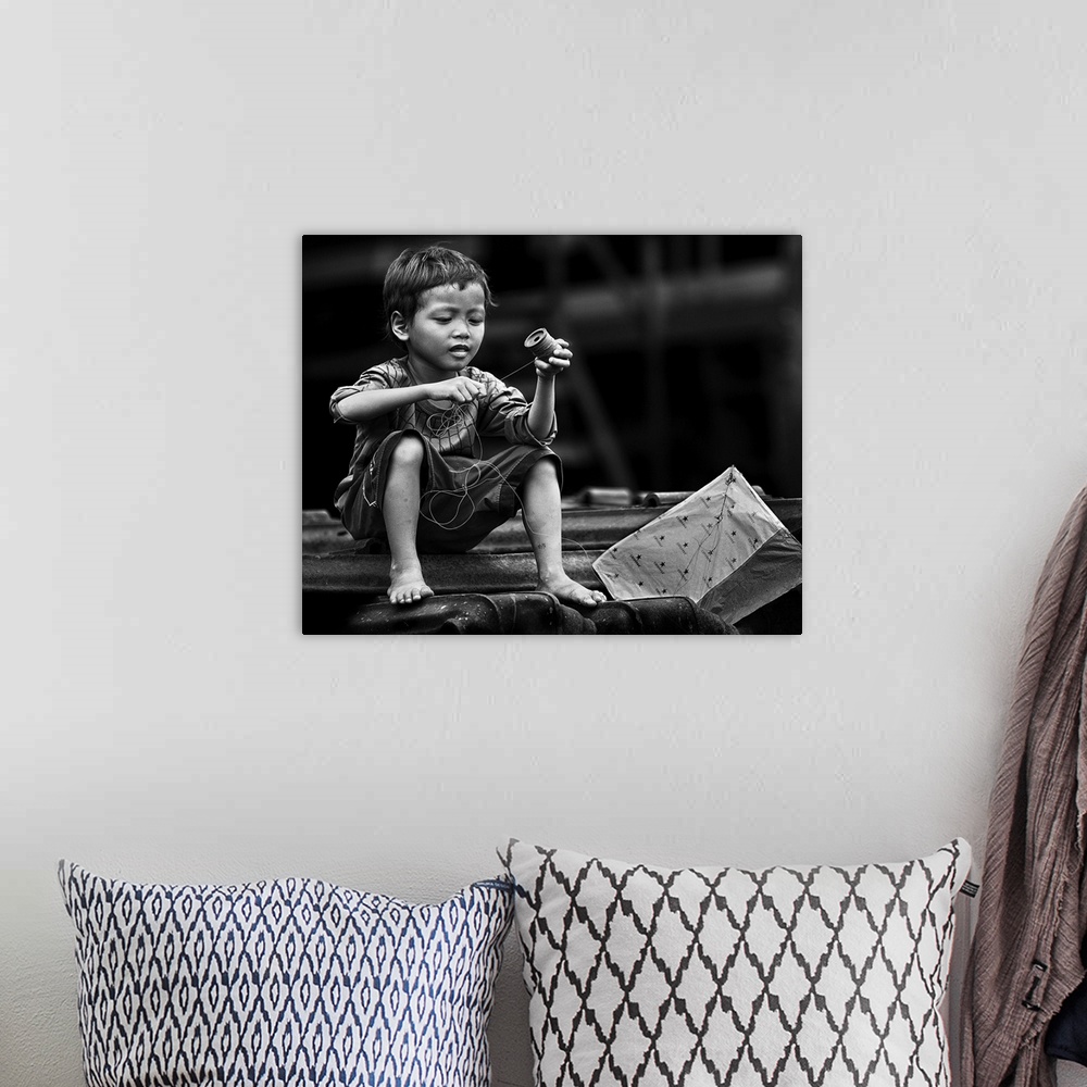 A bohemian room featuring Black and white image of a boy winding the string of his kite.