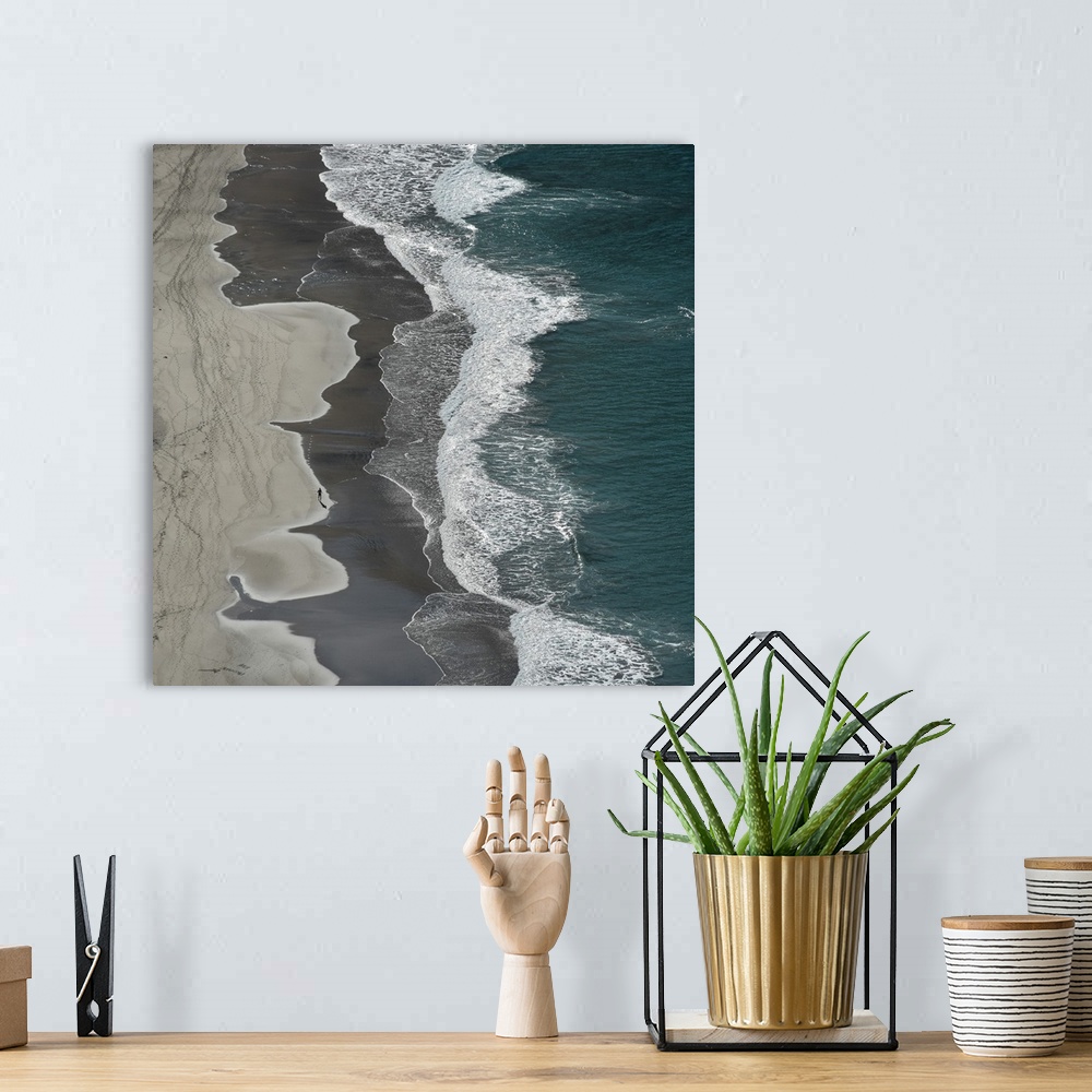 A bohemian room featuring Aerial photograph of the ocean shore with tan, gray, white, and blue vertical separations.