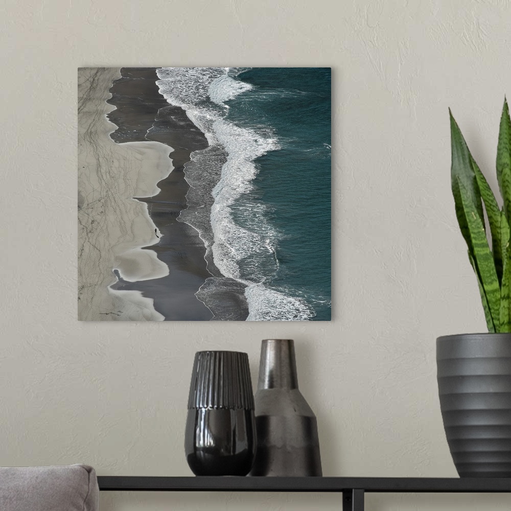 A modern room featuring Aerial photograph of the ocean shore with tan, gray, white, and blue vertical separations.
