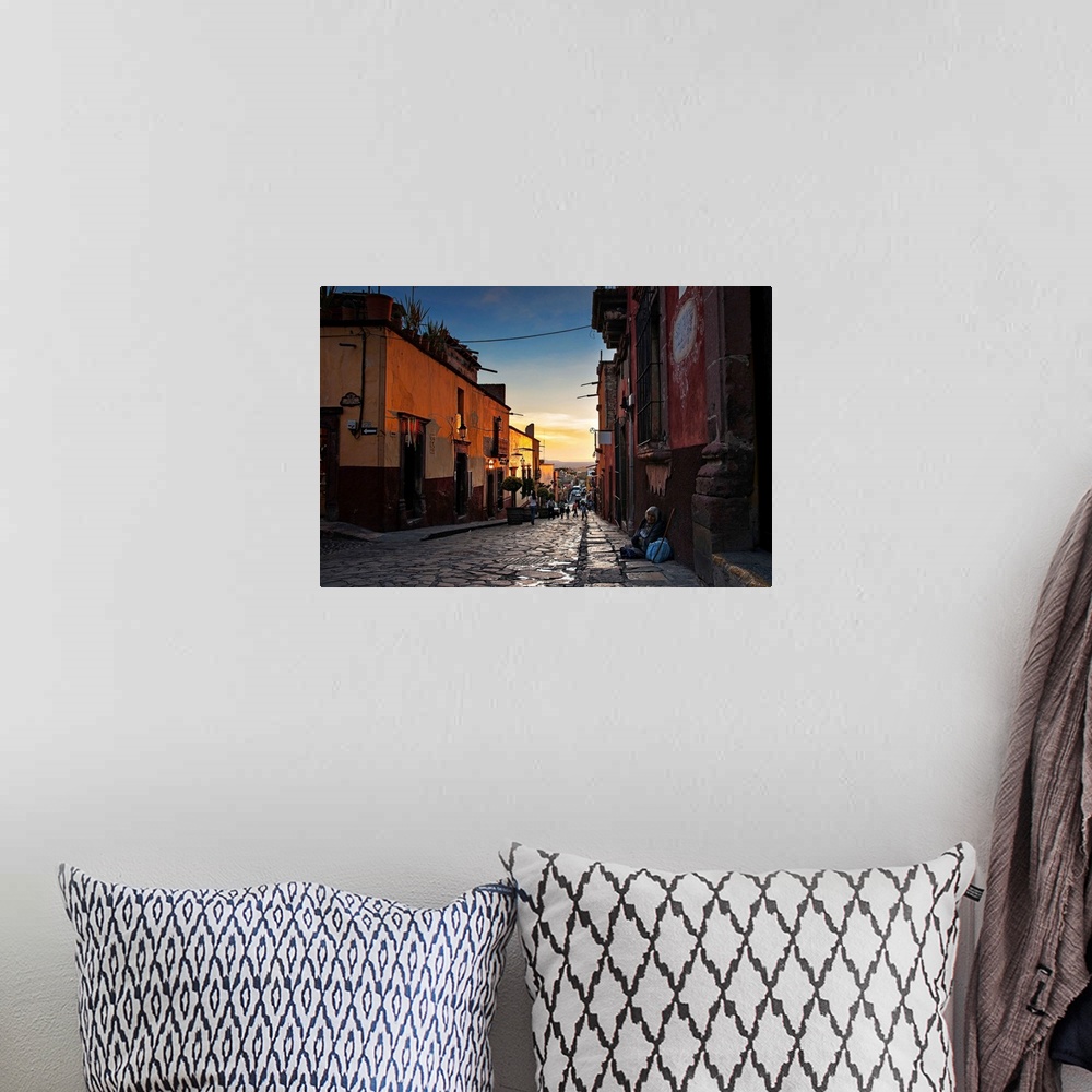 A bohemian room featuring Looking down the street of a Mexican city at dusk.