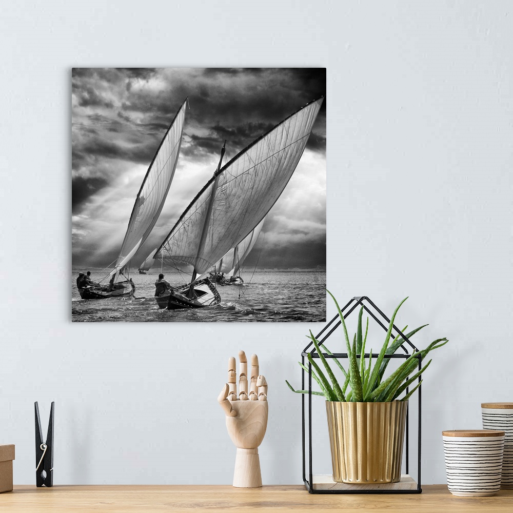A bohemian room featuring Black and white image of a fleet of sailboats leaning in the wind under stormy skies.
