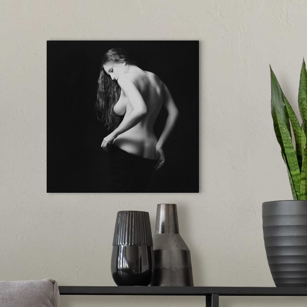 A modern room featuring A black and white portrait of nude woman from behind partially exposed.
