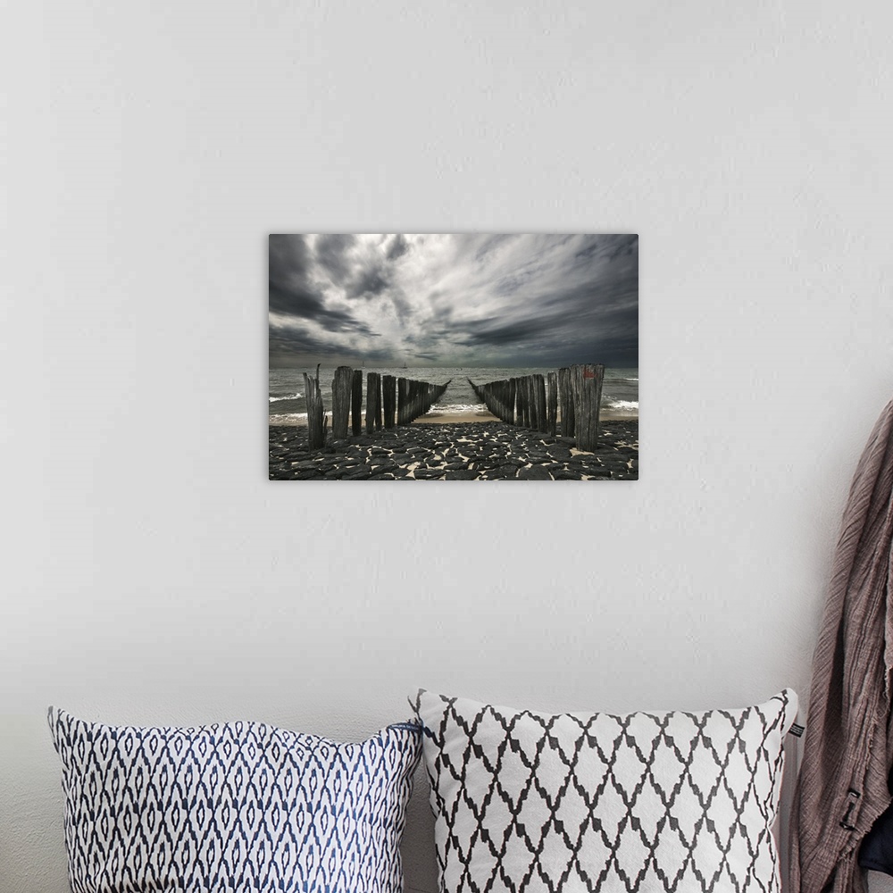 A bohemian room featuring Landscape photograph of the ocean and the remains of a pier on an overcast, gloomy day.