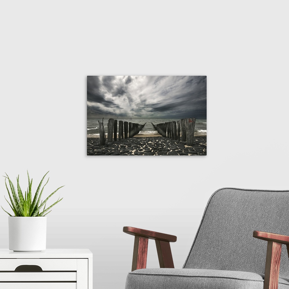 A modern room featuring Landscape photograph of the ocean and the remains of a pier on an overcast, gloomy day.