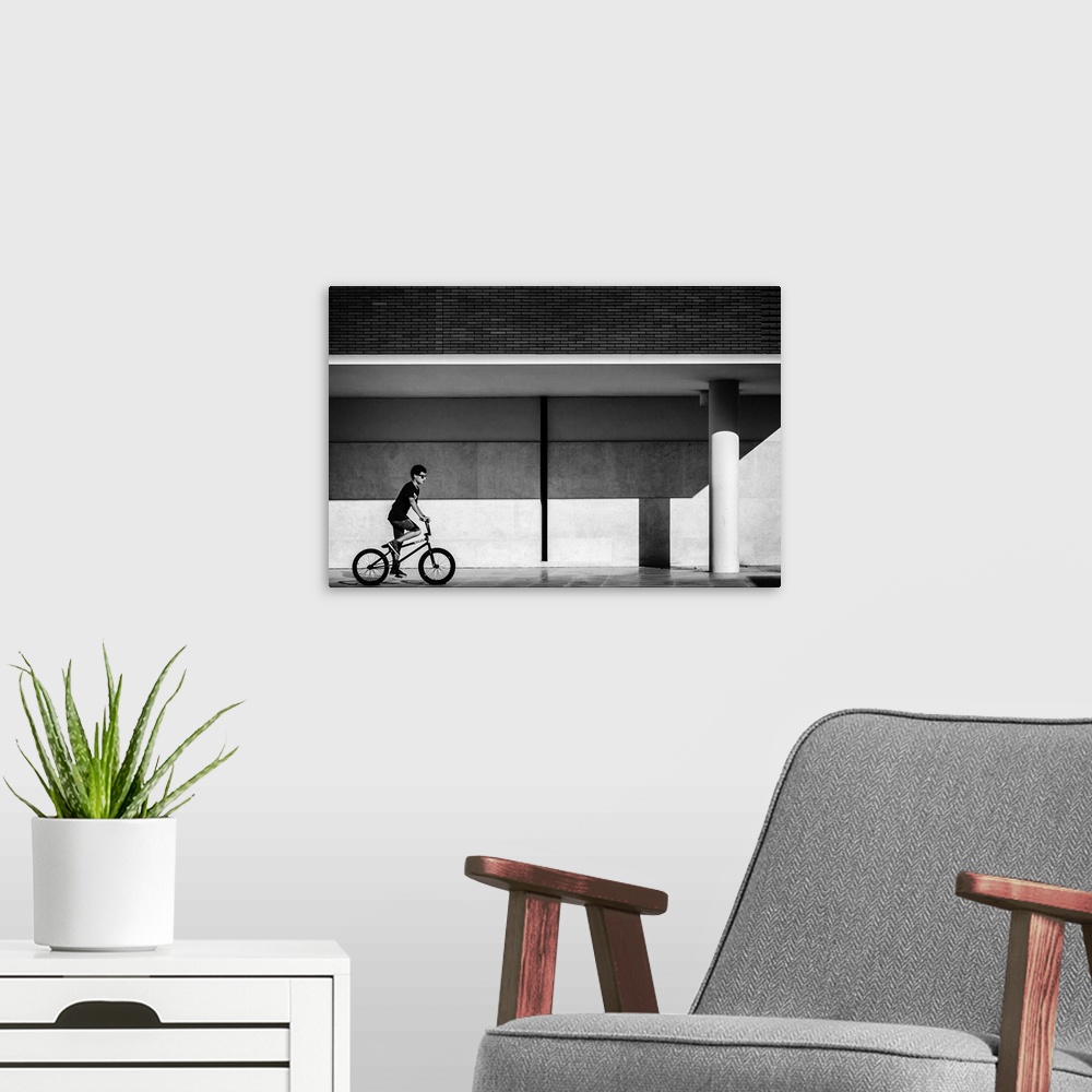 A modern room featuring a black and white photograph of a boy riding a bike.