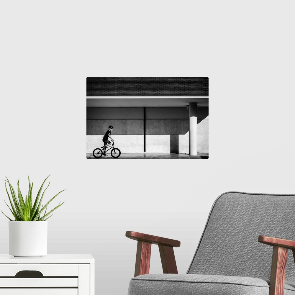 A modern room featuring a black and white photograph of a boy riding a bike.