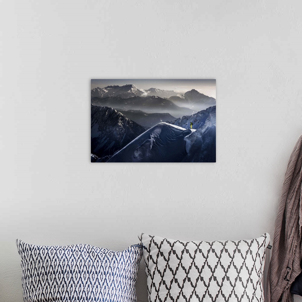 A bohemian room featuring A skier pauses at the top of a mountain, with peaks of neighboring mountains in the background.