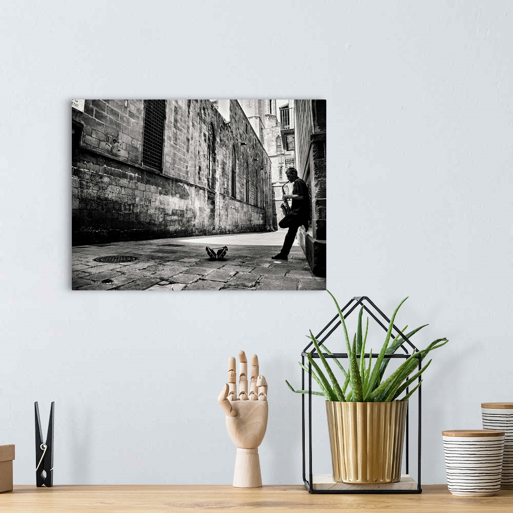 A bohemian room featuring A black and white photograph of a person playing a saxophone in an alley.