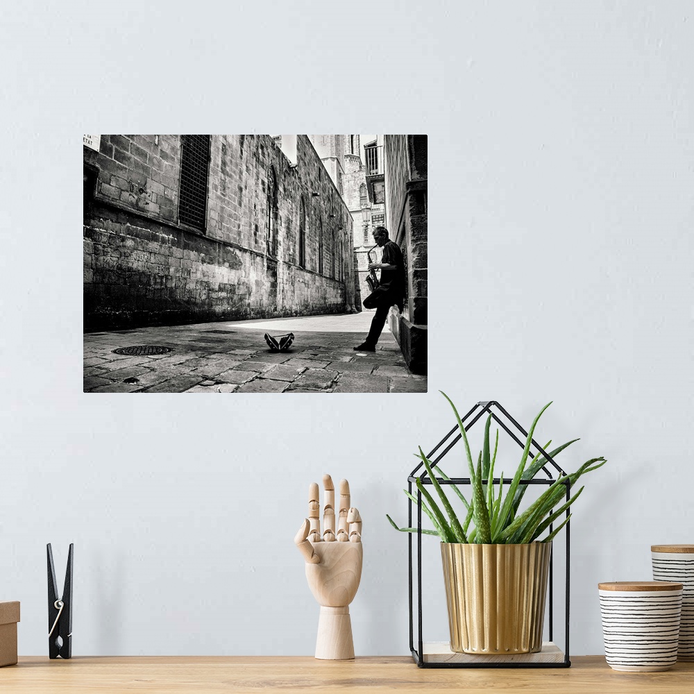 A bohemian room featuring A black and white photograph of a person playing a saxophone in an alley.