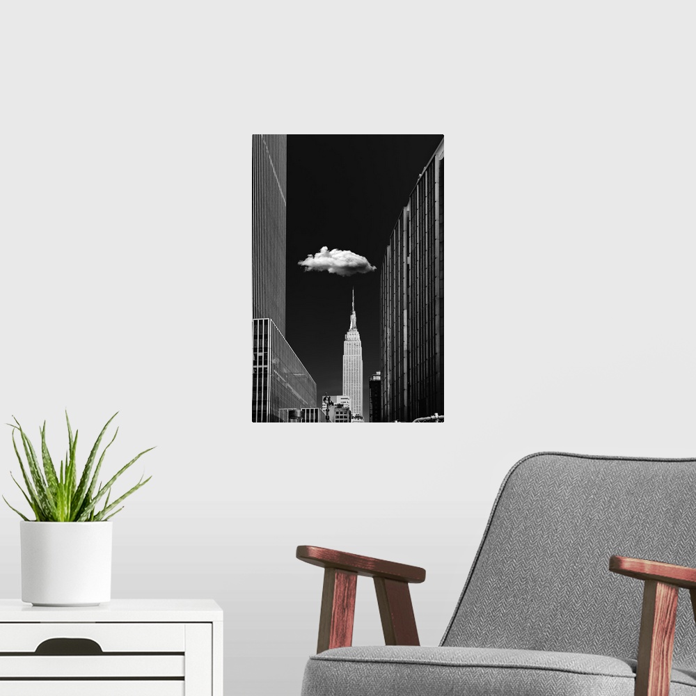 A modern room featuring Black and white photograph of a New York City cityscape highlighting the single cloud hanging ove...