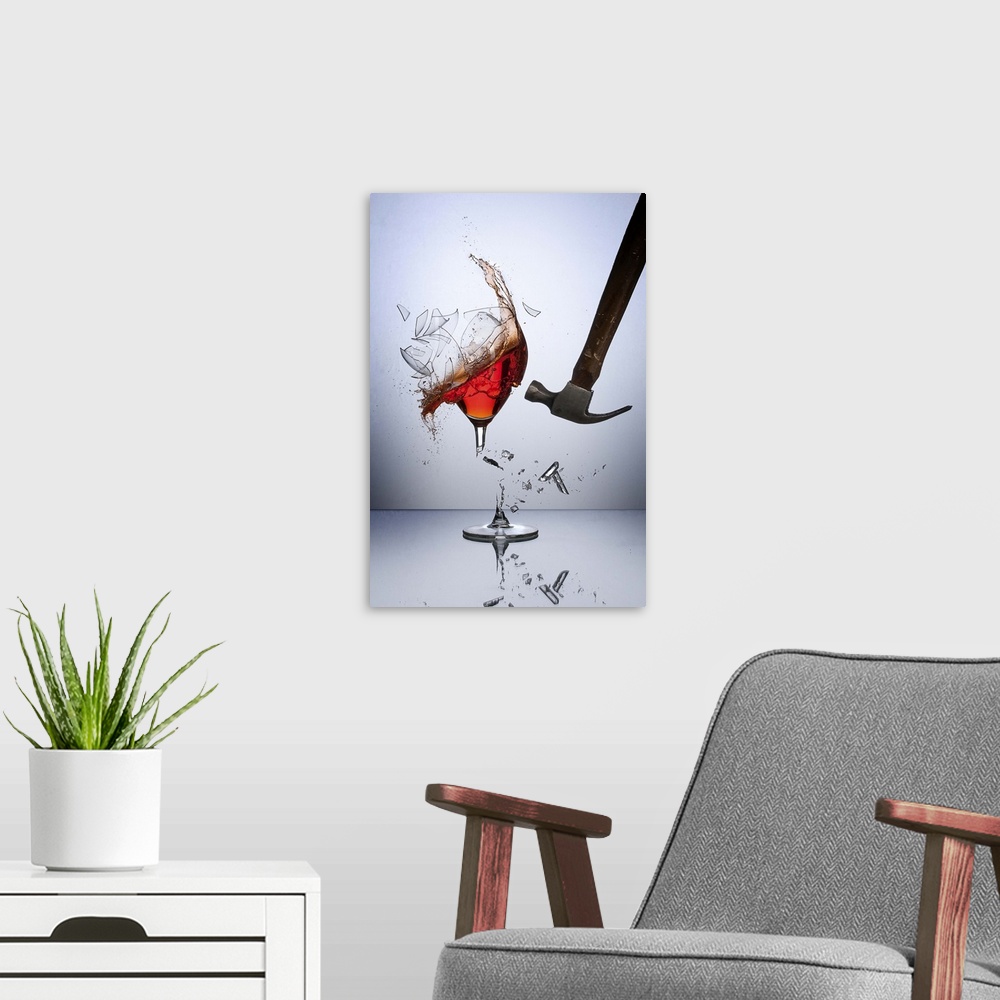 A modern room featuring A hammer smashing a glass of wine, sending glass shards flying.