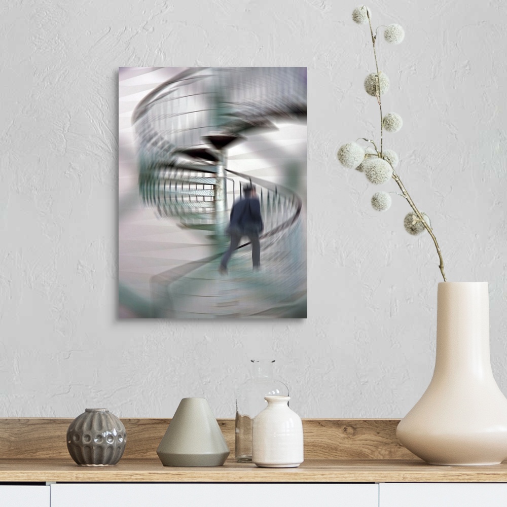 A farmhouse room featuring A blurred motion photo of a businessman talking up a spiral staircase.