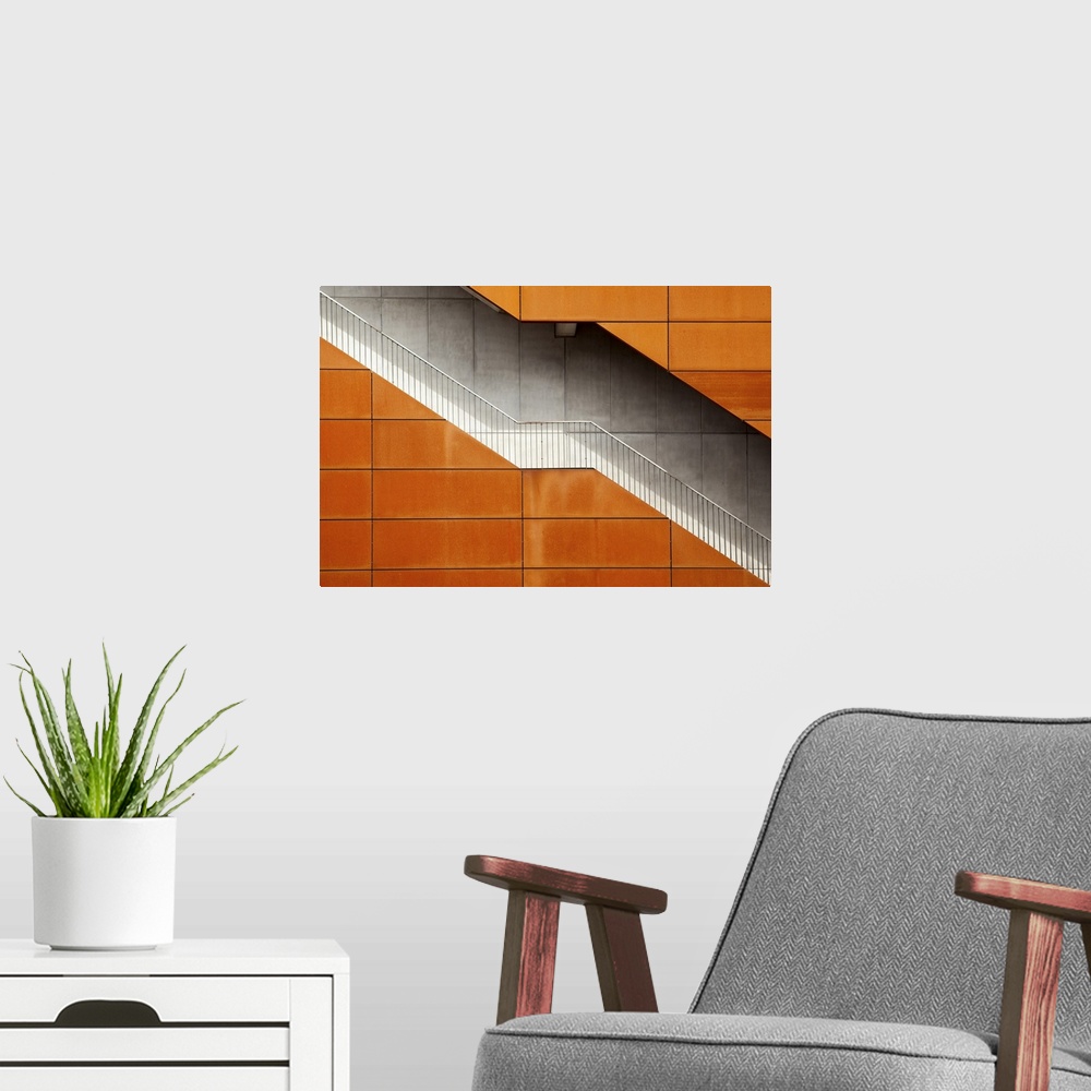 A modern room featuring A stairway cutting through an building with an orange facade, Amsterdam.