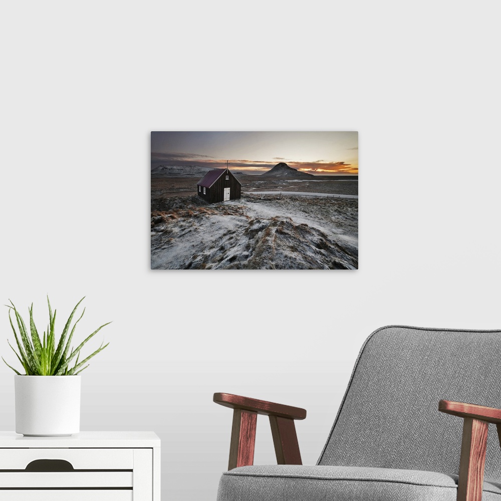 A modern room featuring Small church in the icy rural landscape of Iceland, during sunset.