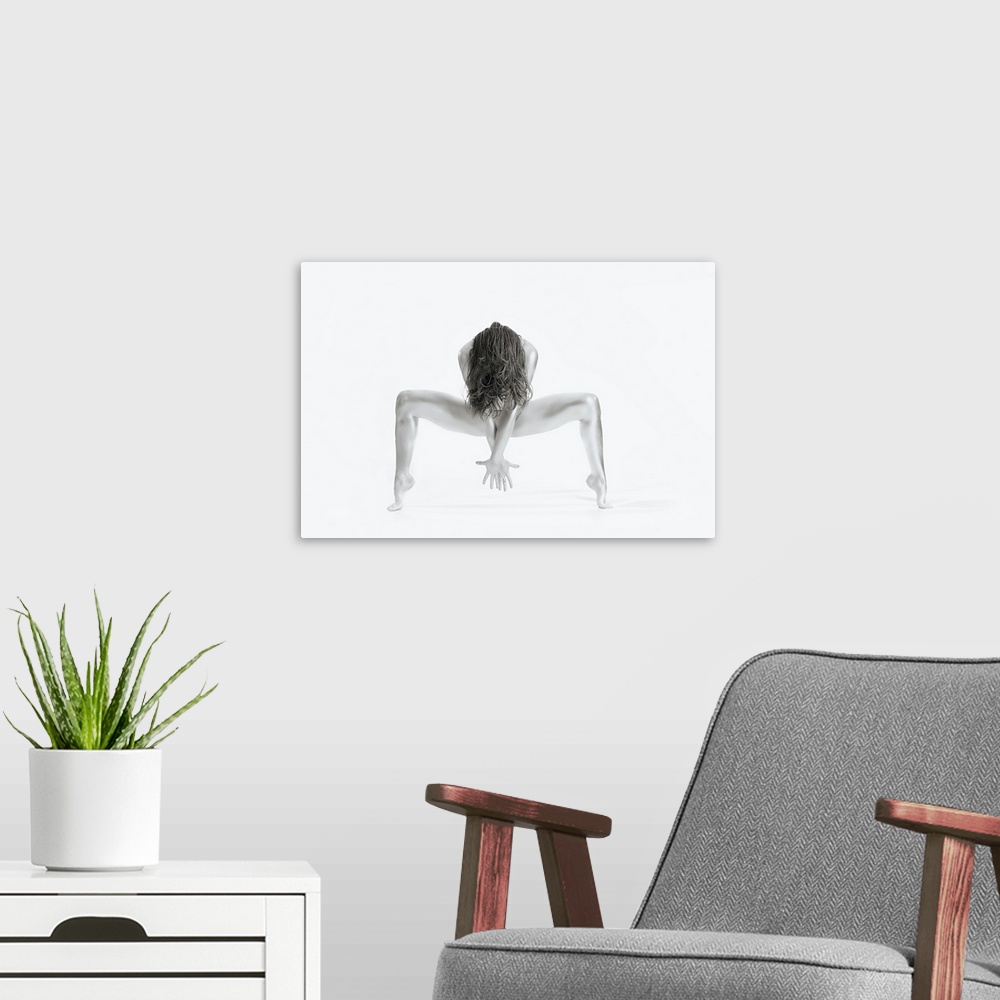A modern room featuring High key black and white portrait of a nude woman balancing and creating shapes with her body.