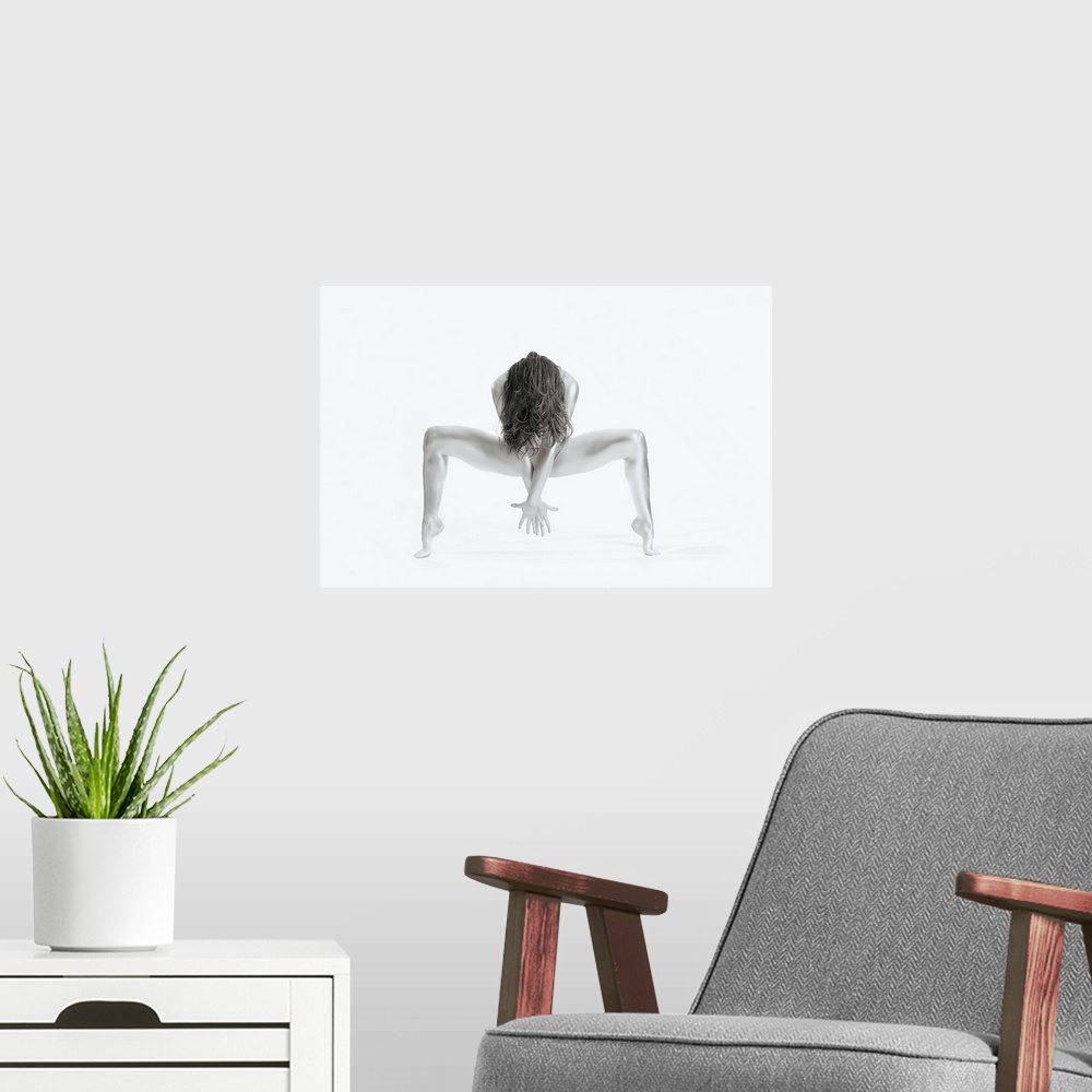 A modern room featuring High key black and white portrait of a nude woman balancing and creating shapes with her body.
