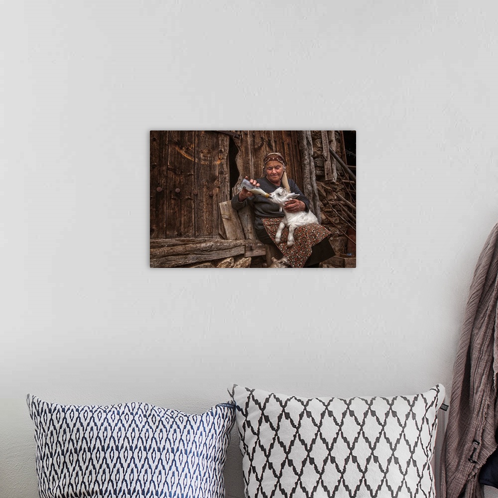 A bohemian room featuring A portrait of an old woman feeding a young goat.