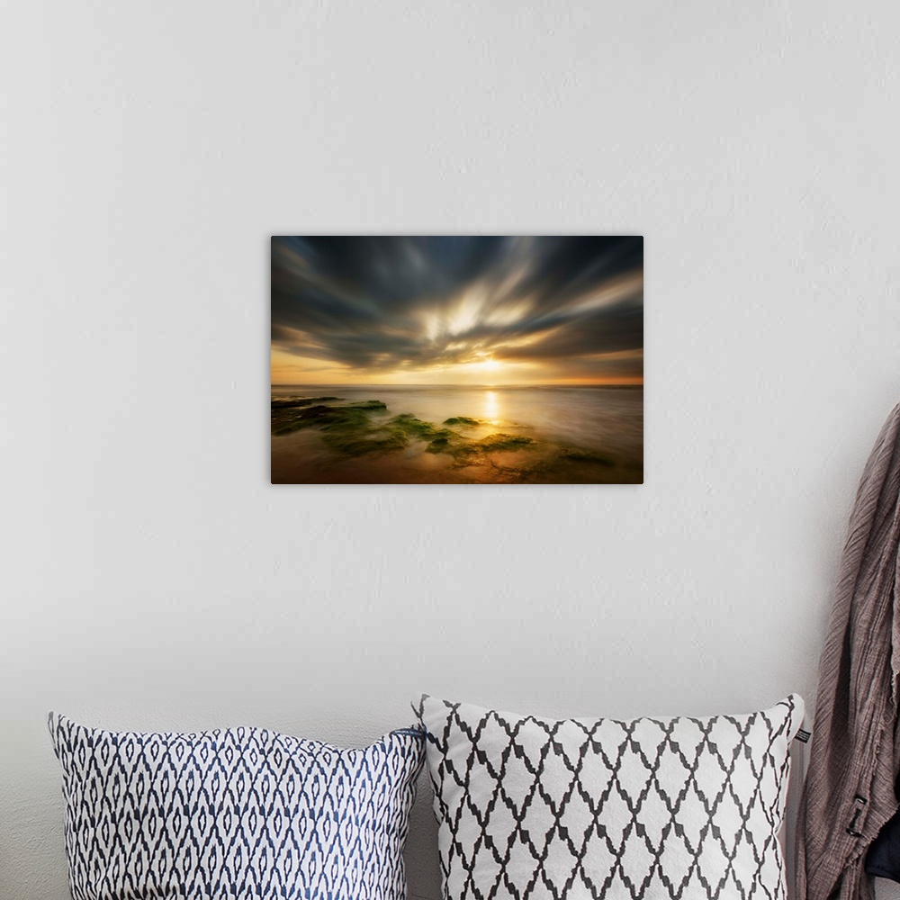 A bohemian room featuring Dramatic clouds at sunrise over the coast of Spain.