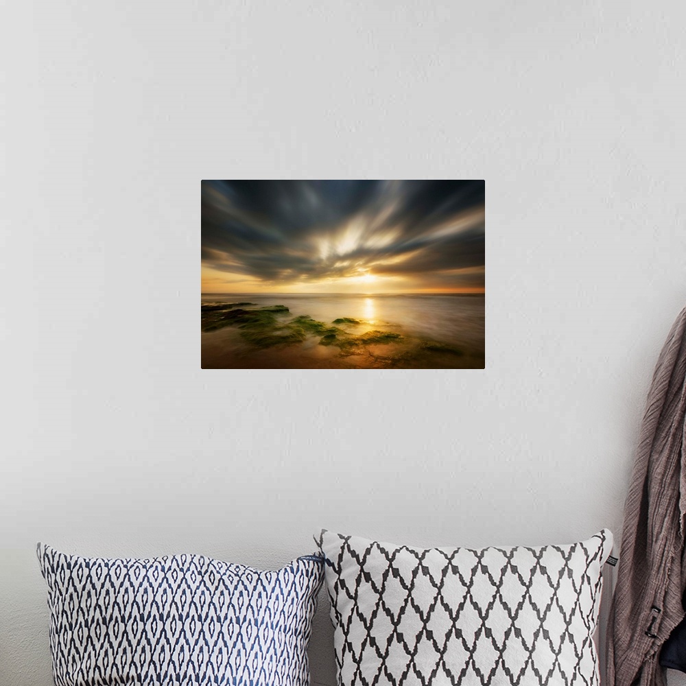A bohemian room featuring Dramatic clouds at sunrise over the coast of Spain.