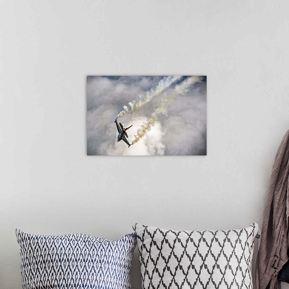 A bohemian room featuring A jet airplane dives in the sky, leaving twin contrails from its wings.