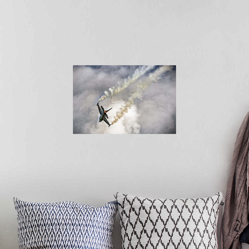 A bohemian room featuring A jet airplane dives in the sky, leaving twin contrails from its wings.