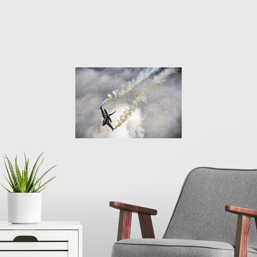 A modern room featuring A jet airplane dives in the sky, leaving twin contrails from its wings.