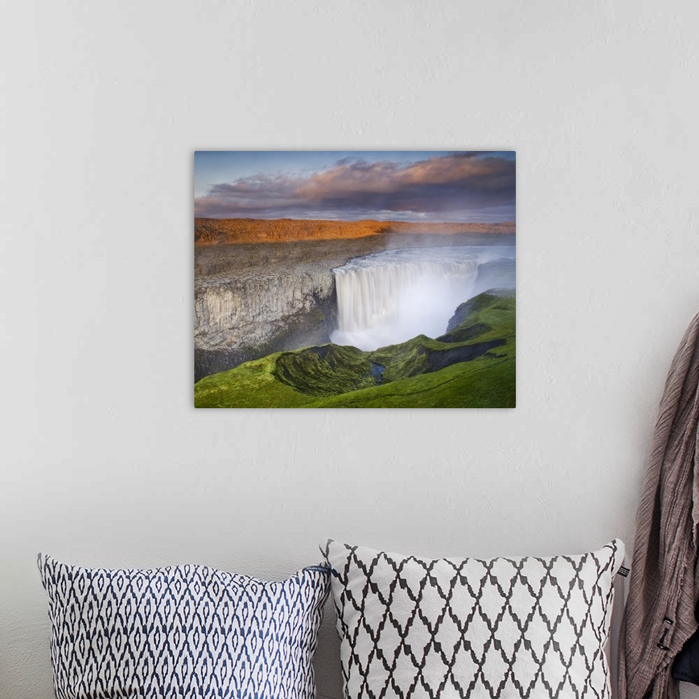 A bohemian room featuring A large waterfall in Iceland in a colorful landscape at sunset.